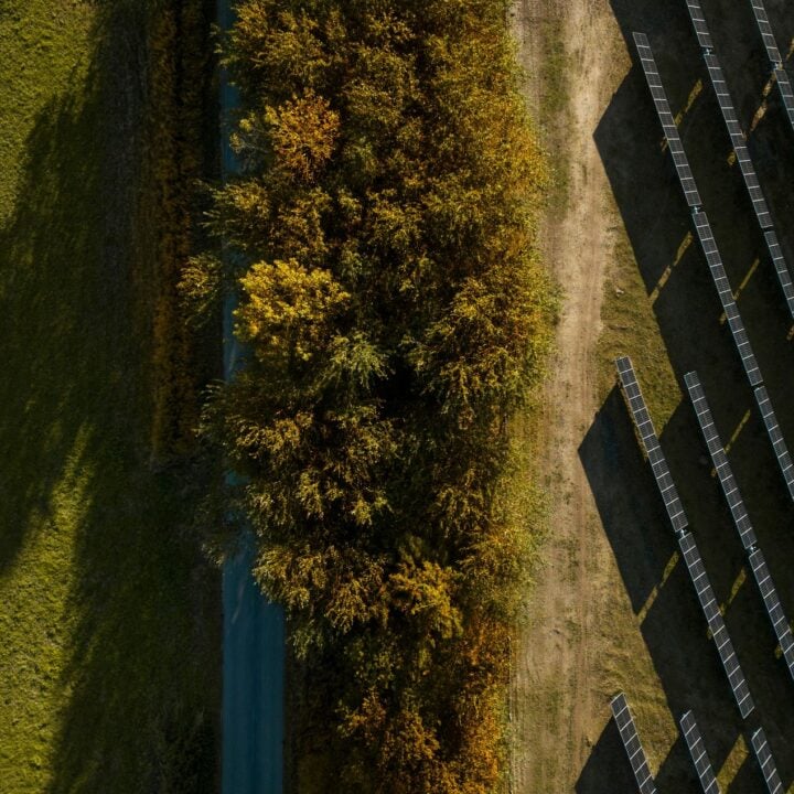Drone photo of Lidsø solar park in Denmark with trees and foliage